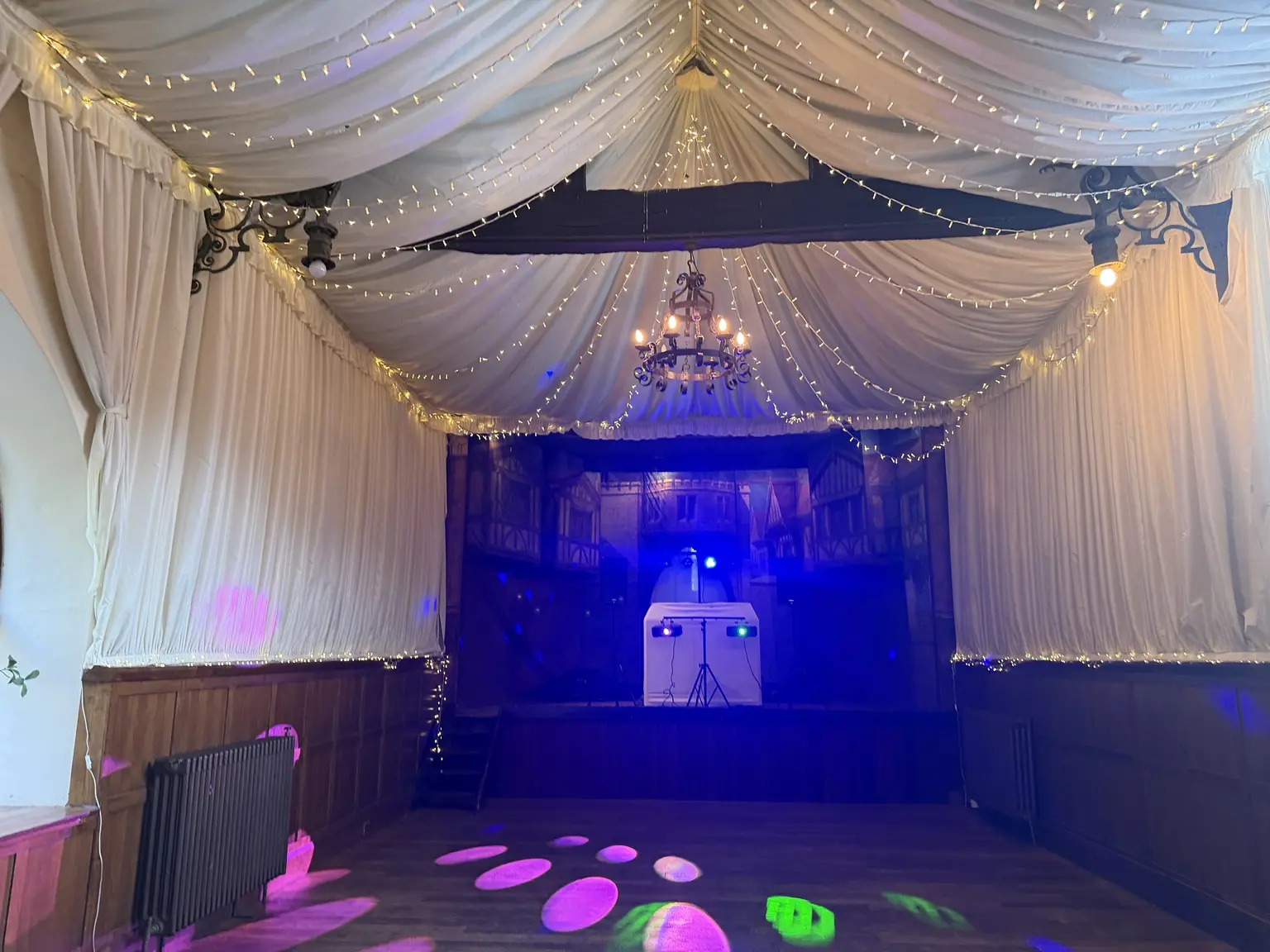 Hurricane Roadshow DJ setup casting coloured lighting across the dance floor at How Caple Court